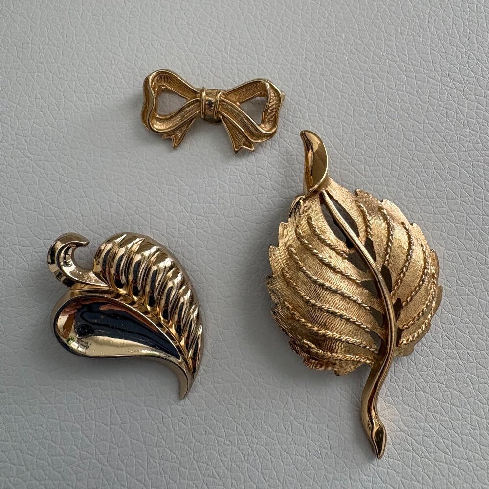 Three Vintage Gold Tone Brooches Two Leaves and a Bow